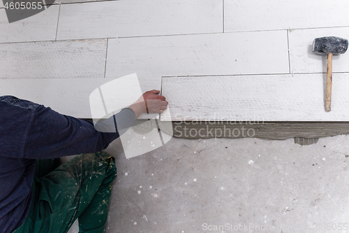 Image of worker installing the ceramic wood effect tiles on the floor