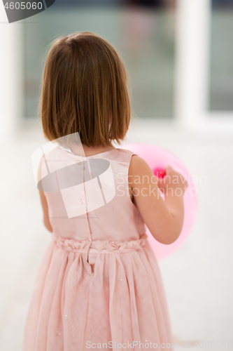 Image of cute little girl playing with balloons