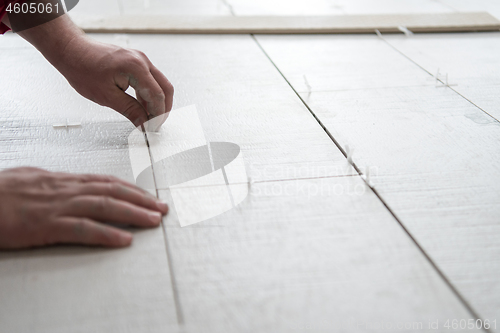 Image of worker installing the ceramic wood effect tiles on the floor