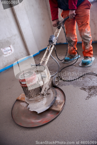 Image of worker performing and polishing sand and cement screed floor