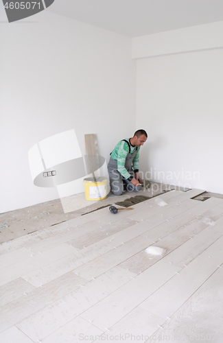 Image of worker installing the ceramic wood effect tiles on the floor