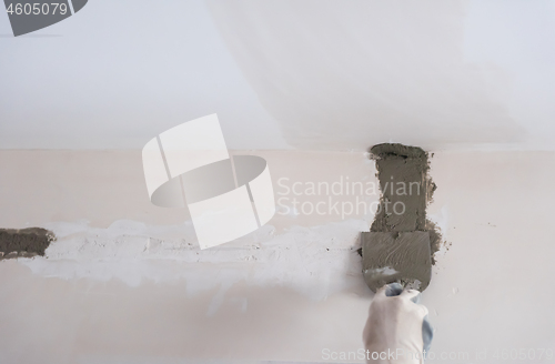 Image of construction worker plastering on gypsum walls