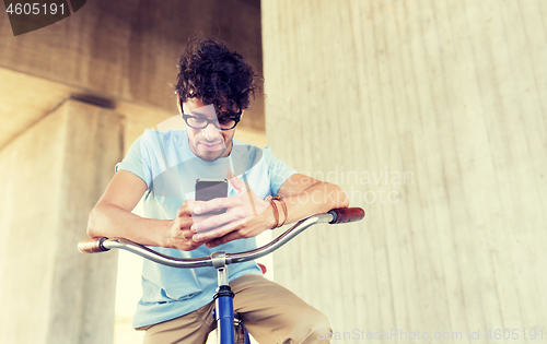 Image of man with smartphone and fixed gear bike on street