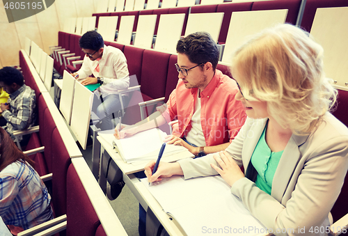 Image of group of students with notebooks at lecture hall