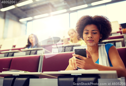 Image of african student girl with smartphone at lecture