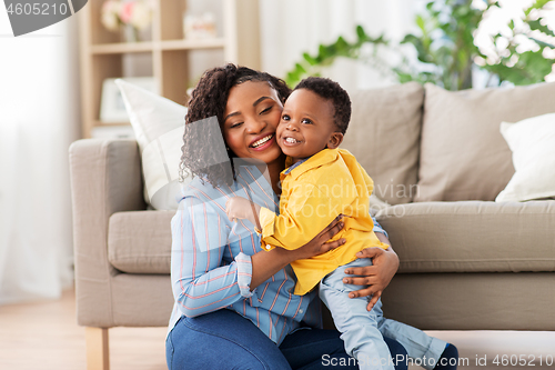 Image of happy african american mother with baby at home