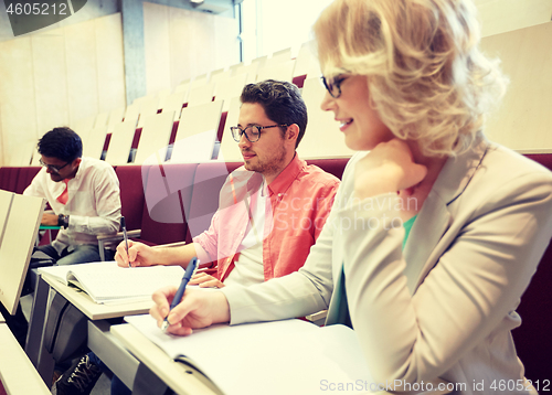 Image of group of students with notebooks at lecture hall