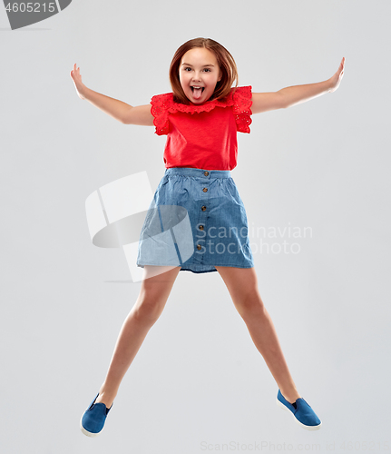 Image of happy smiling girl in red shirt and skirt jumping