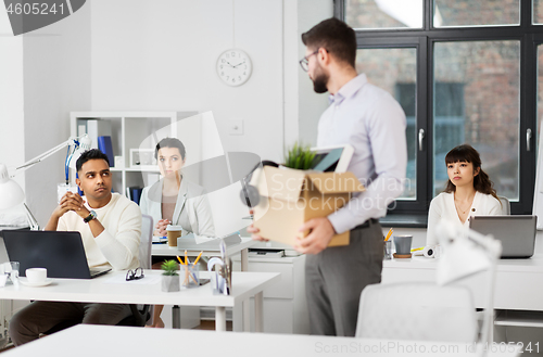 Image of fired male office worker with personal stuff