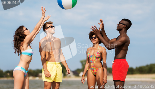 Image of friends playing with beach ball in summer