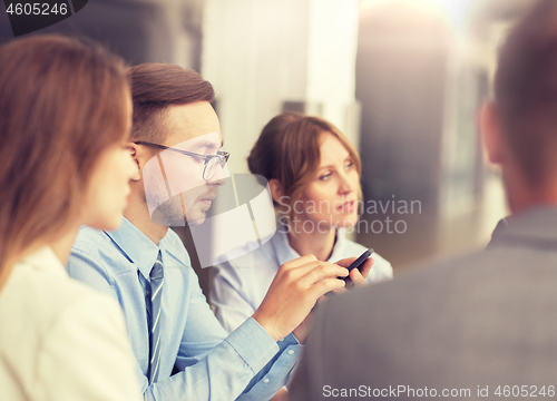 Image of businessman texting on smartphone at office