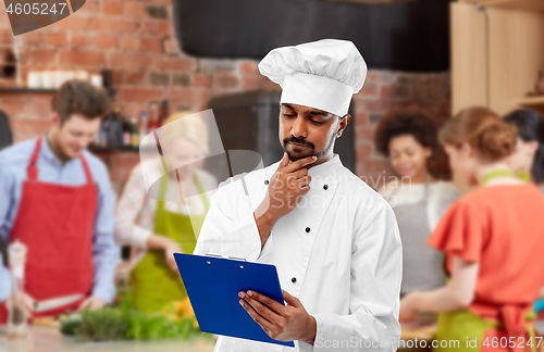 Image of chef with menu on clipboard at cooking class