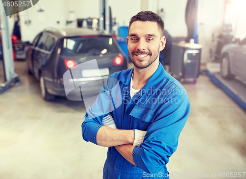 Image of happy auto mechanic man or smith at car workshop