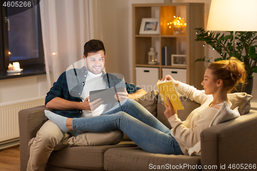 Image of couple with tablet computer and book at home