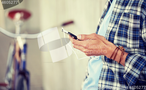 Image of man with earphones and smartphone listening music