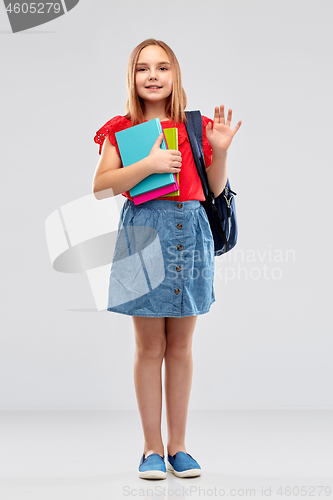 Image of happy student girl with books and bag waving hand