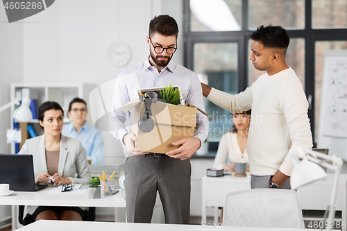 Image of colleague seeing off sad fired male office worker