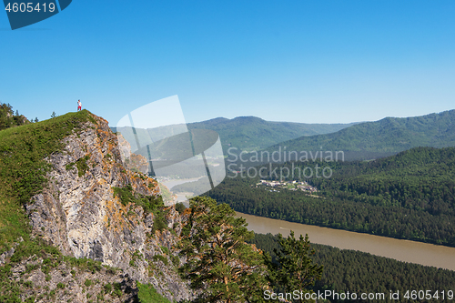 Image of Man standing on top of cliff