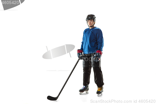 Image of Young female hockey player with the stick on ice court and white background