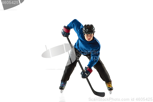 Image of Young female hockey player with the stick on ice court and white background