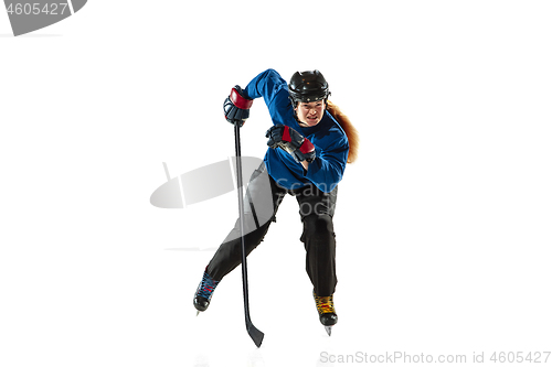 Image of Young female hockey player with the stick on ice court and white background