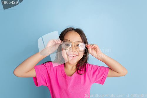 Image of Caucasian little girl\'s portrait on blue studio background