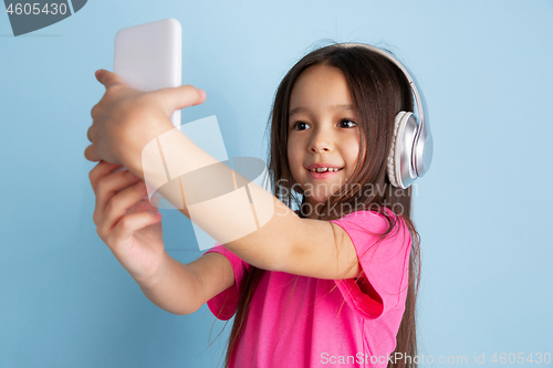 Image of Caucasian little girl\'s portrait on blue studio background