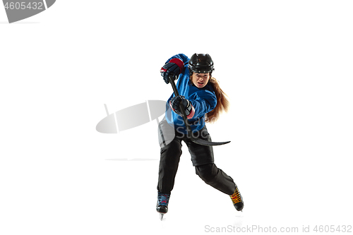 Image of Young female hockey player with the stick on ice court and white background