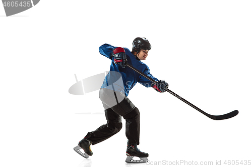 Image of Young female hockey player with the stick on ice court and white background