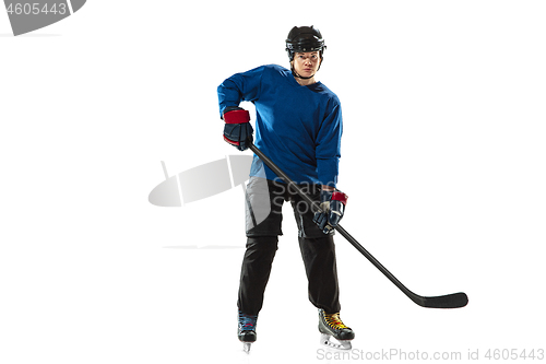 Image of Young female hockey player with the stick on ice court and white background