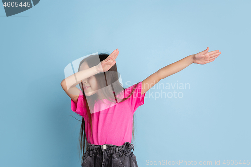 Image of Caucasian little girl\'s portrait on blue studio background