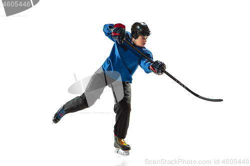 Image of Young female hockey player with the stick on ice court and white background