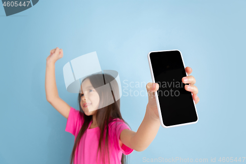 Image of Caucasian little girl\'s portrait on blue studio background