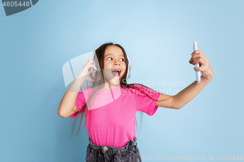 Image of Caucasian little girl\'s portrait on blue studio background