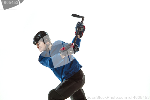 Image of Young female hockey player with the stick on ice court and white background