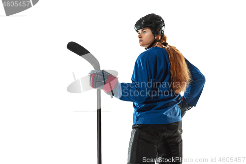 Image of Young female hockey player with the stick on ice court and white background