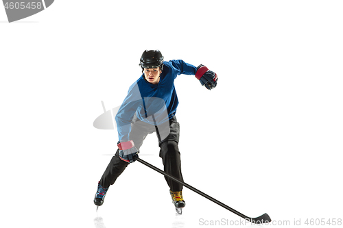 Image of Young female hockey player with the stick on ice court and white background