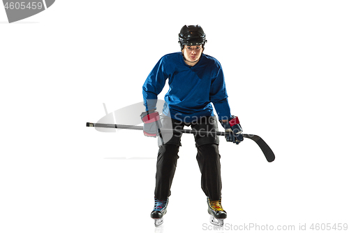 Image of Young female hockey player with the stick on ice court and white background