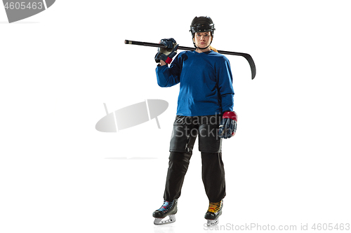 Image of Young female hockey player with the stick on ice court and white background