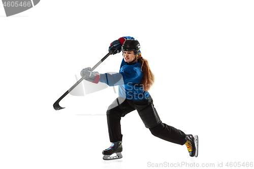 Image of Young female hockey player with the stick on ice court and white background