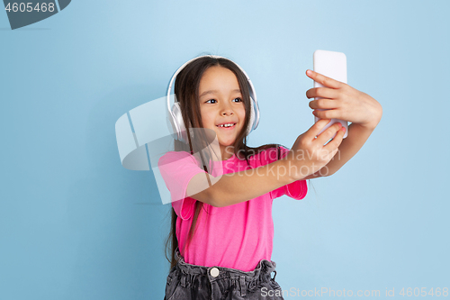 Image of Caucasian little girl\'s portrait on blue studio background