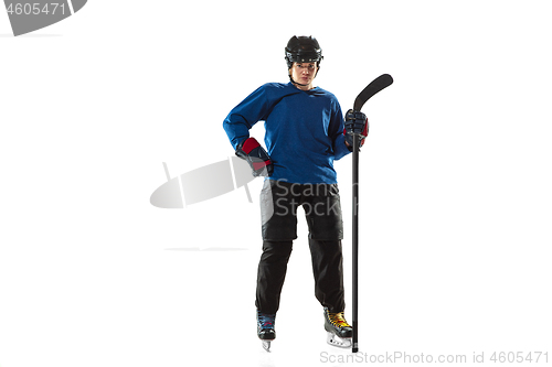 Image of Young female hockey player with the stick on ice court and white background