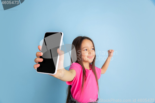 Image of Caucasian little girl\'s portrait on blue studio background