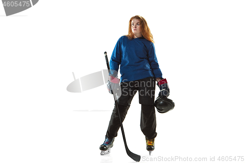 Image of Young female hockey player with the stick on ice court and white background