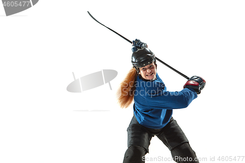 Image of Young female hockey player with the stick on ice court and white background