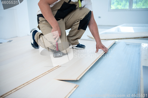 Image of Professional Worker Installing New Laminated Wooden Floor