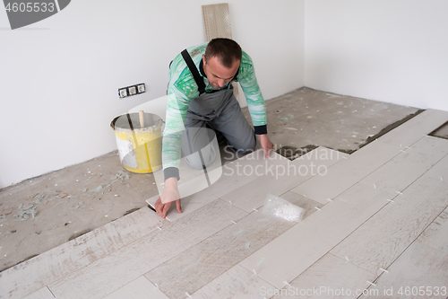 Image of worker installing the ceramic wood effect tiles on the floor