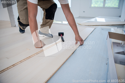 Image of Worker Installing New Laminated Wooden Floor