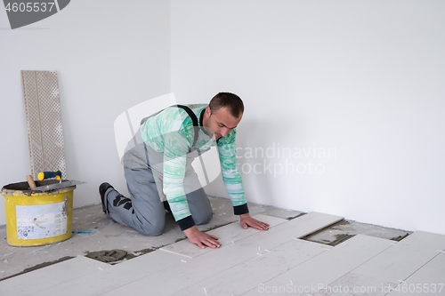 Image of worker installing the ceramic wood effect tiles on the floor