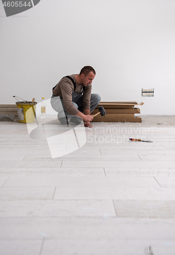 Image of worker installing the ceramic wood effect tiles on the floor